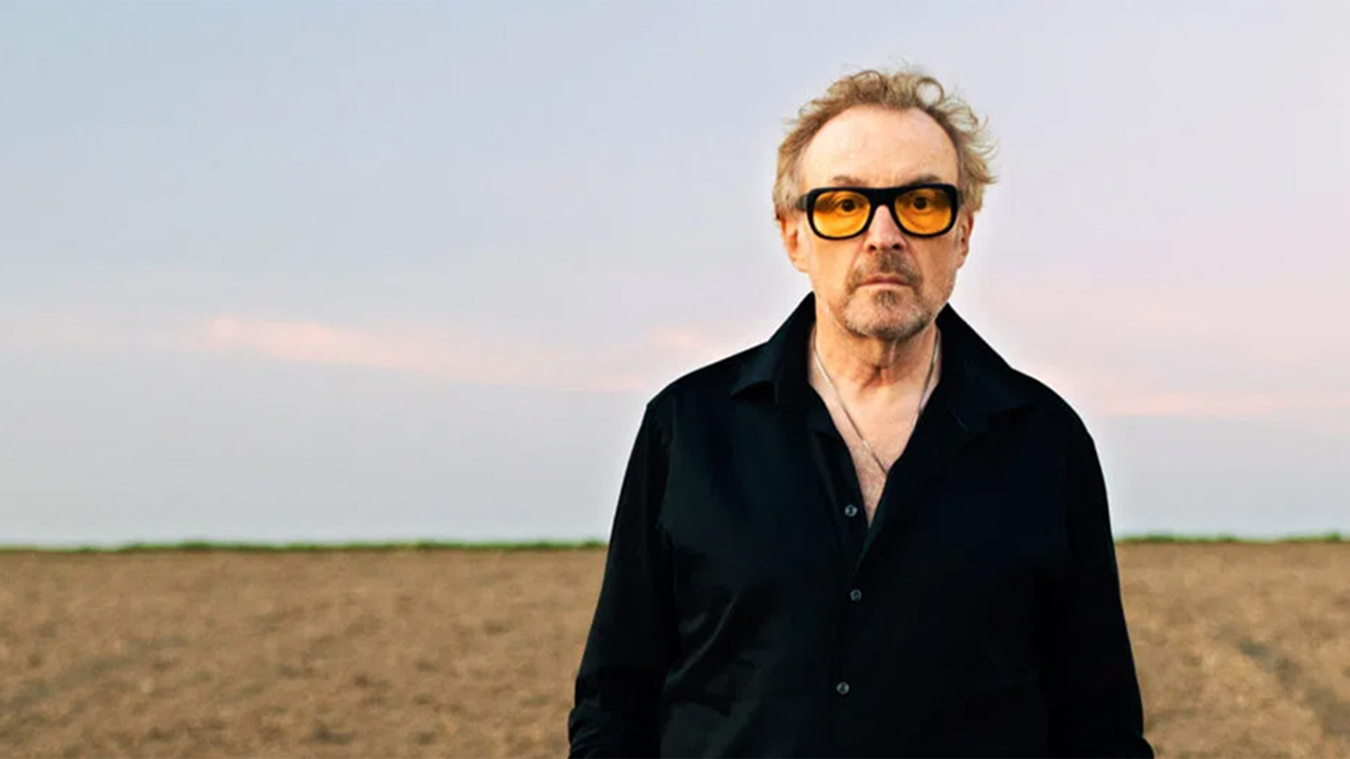 Porträt von Josef Hader, auf einem Feld stehend