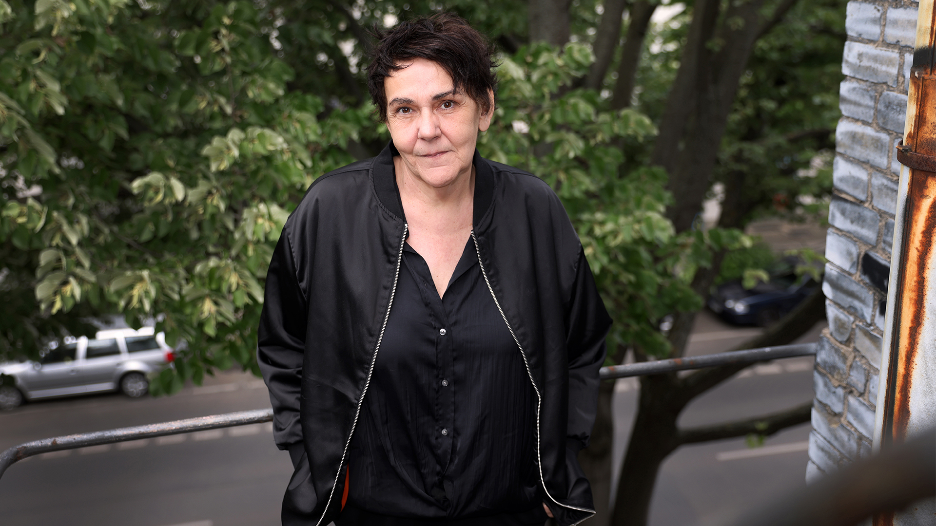 Portrait von christiane Rösinger mit grünen Pflanzen im Hintergrund